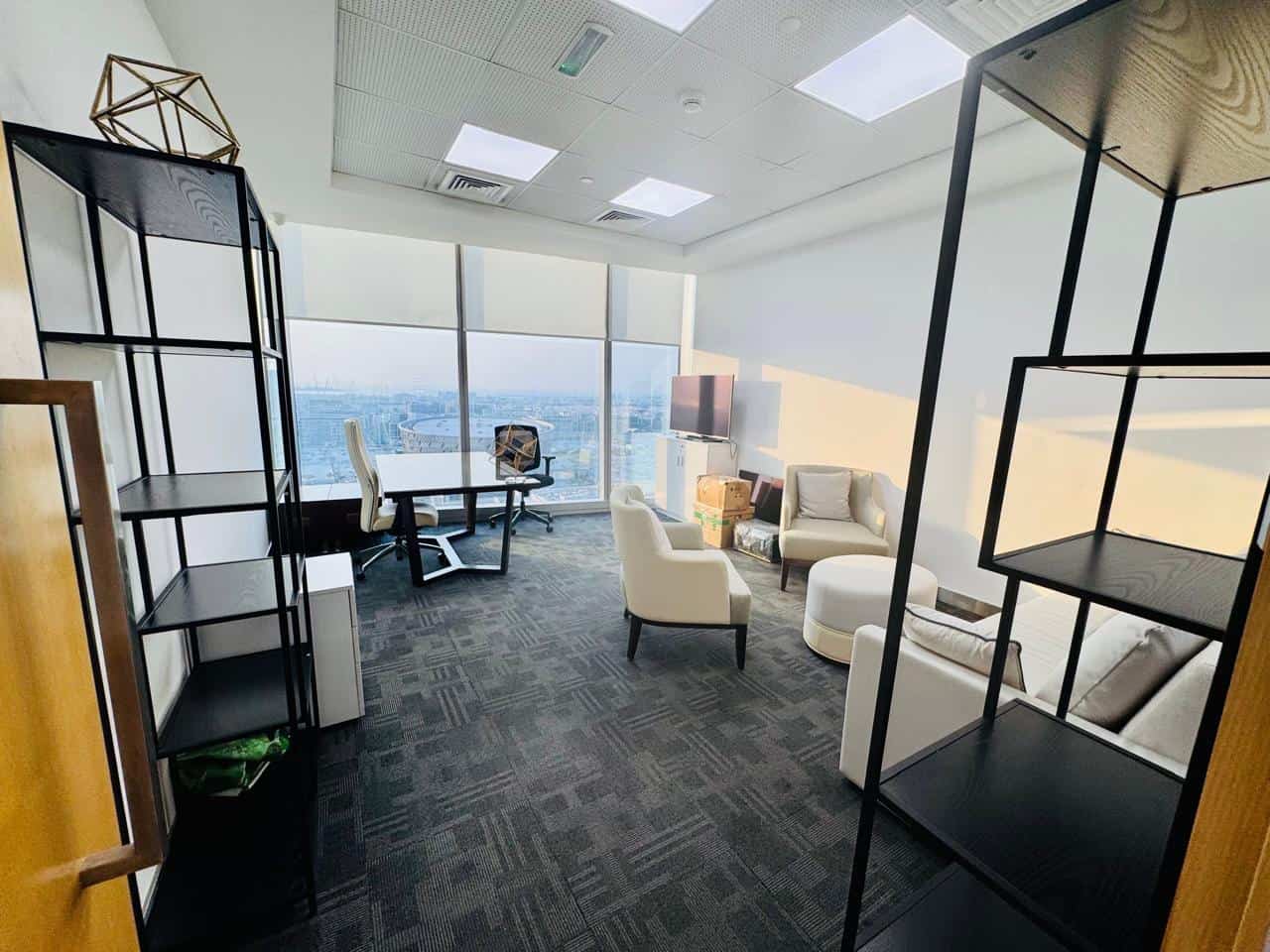 Spacious, bright workspace with stylish furniture and panoramic city skyline views in Dubai UAE.
