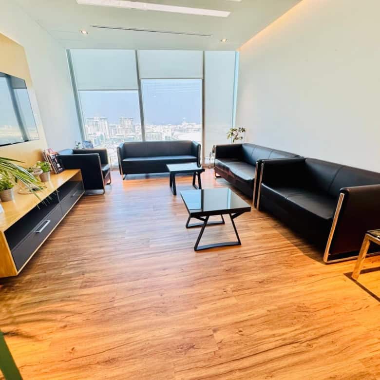 Comfortable, stylish coworking space with sleek black furniture and panoramic city views.