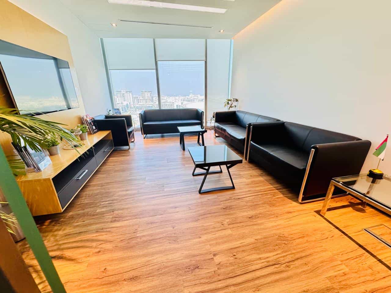 Comfortable, stylish coworking space with sleek black furniture and panoramic city views.
