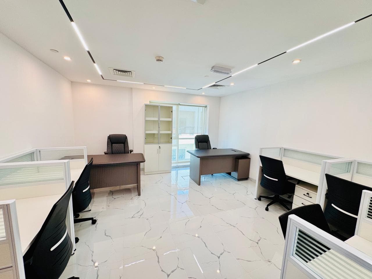 Spacious and professional office setup with collaborative workstations and private executive desks in Dubai.
