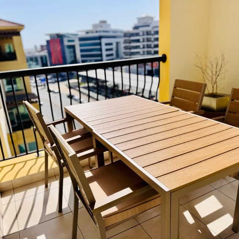 Bright outdoor balcony with table and chairs in UAE coworking space.