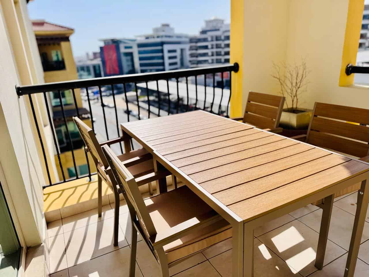 Bright outdoor balcony with table and chairs in UAE coworking space.