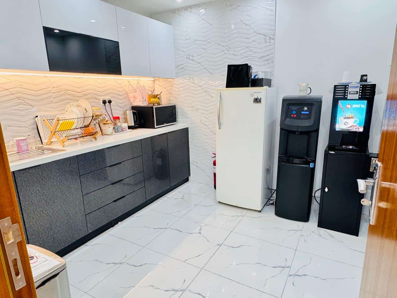 Office kitchenette with appliances, microwave, water cooler, coffee machine in Dubai.