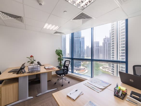 Spacious Dubai office with large windows showcasing skyline and river views.