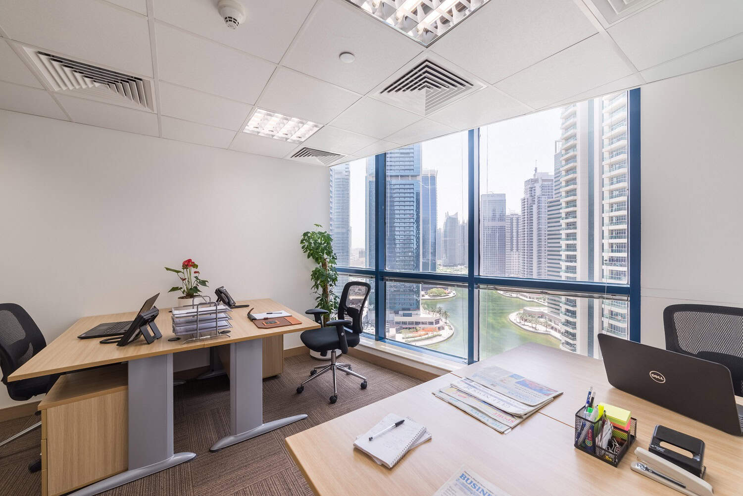Spacious Dubai office with large windows showcasing skyline and river views.