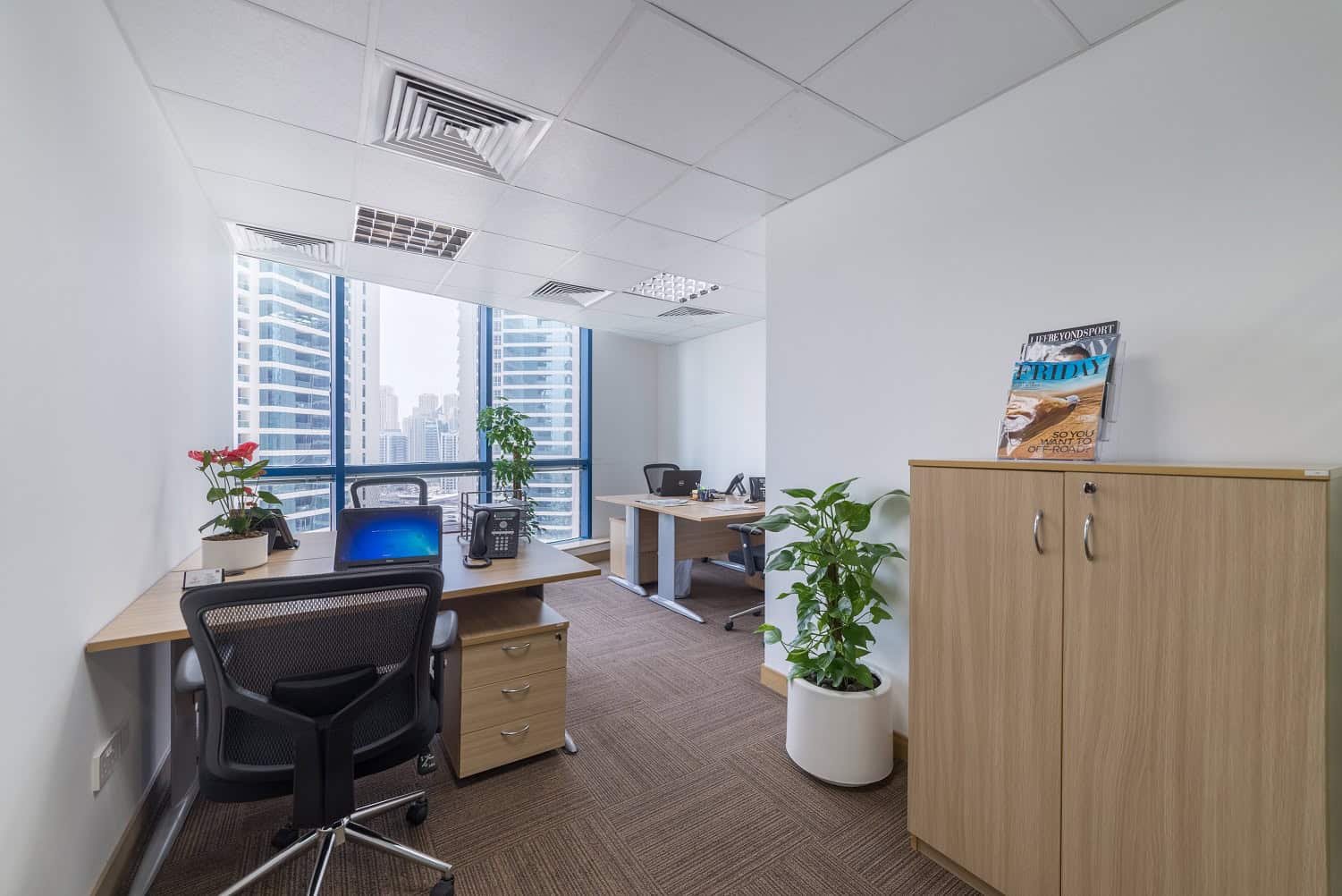 Bright office workspace in Dubai with large windows and coworking desks.
