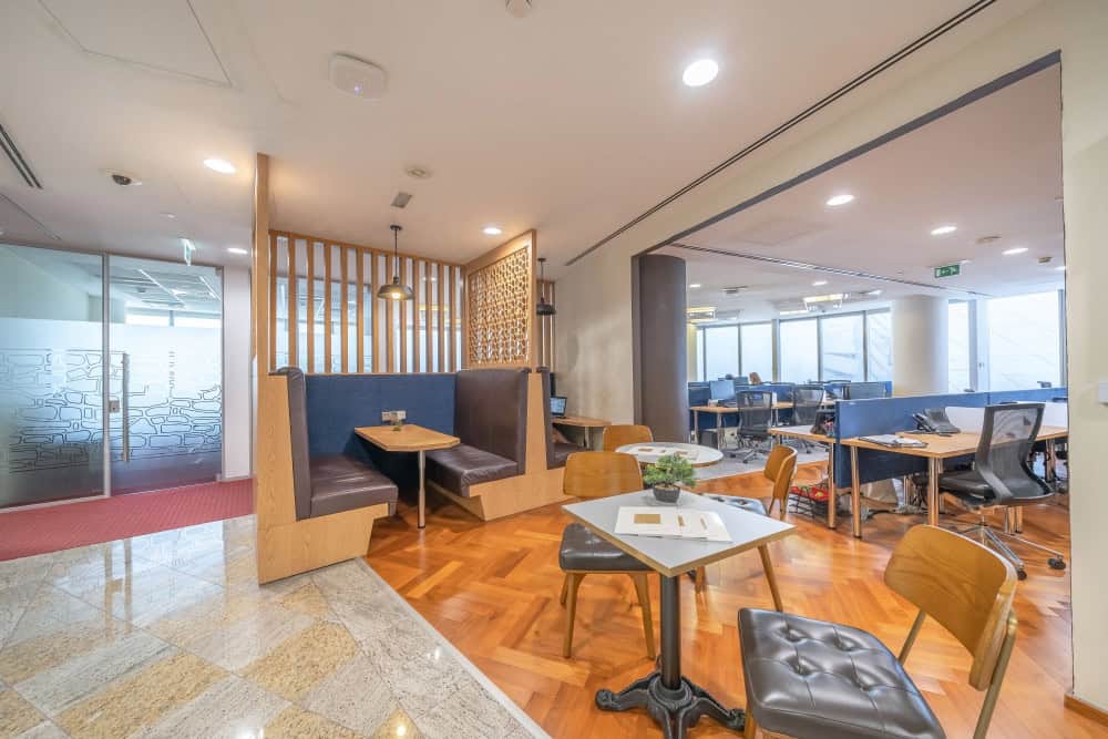 Spacious office environment in Dubai featuring private work booths, open desk areas, and large windows for productivity.