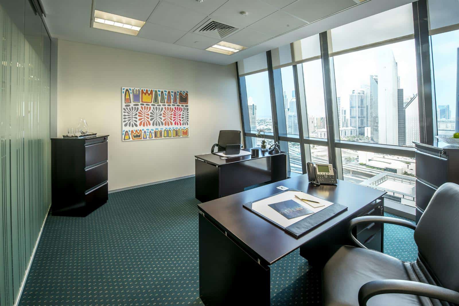 Bright office with large windows and city view, perfect for remote work and business meetings.