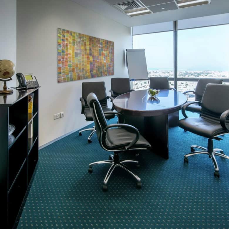 Versatile coworking space featuring a conference table, large window view, and professional decor.