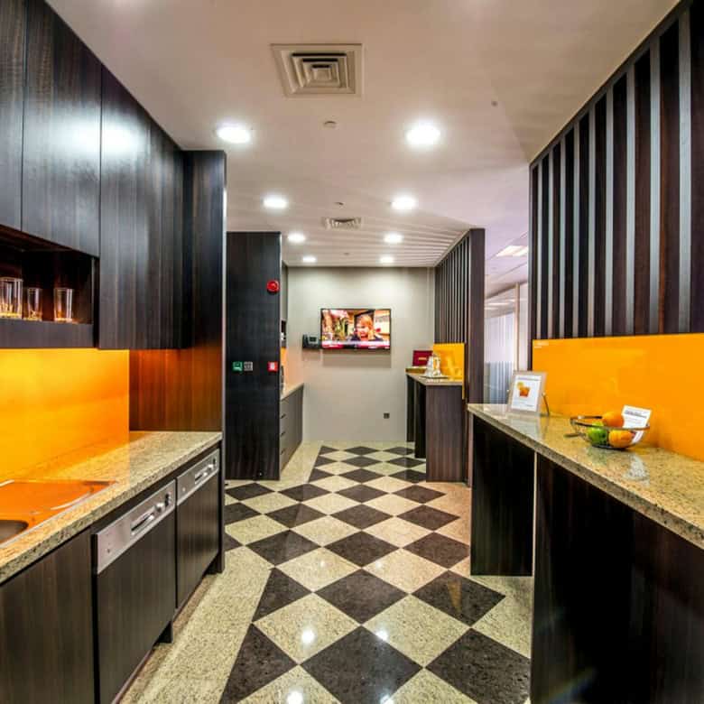 Bright indoor workspace with kitchenette and colorful decor at Nextspace UAE coworking hub.