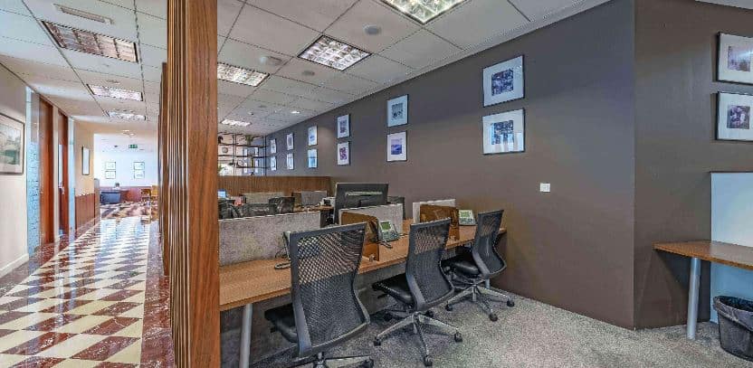 Modern coworking space at Nextspace UAE. Comfortable desks and ergonomic chairs near vibrant framed wall art.