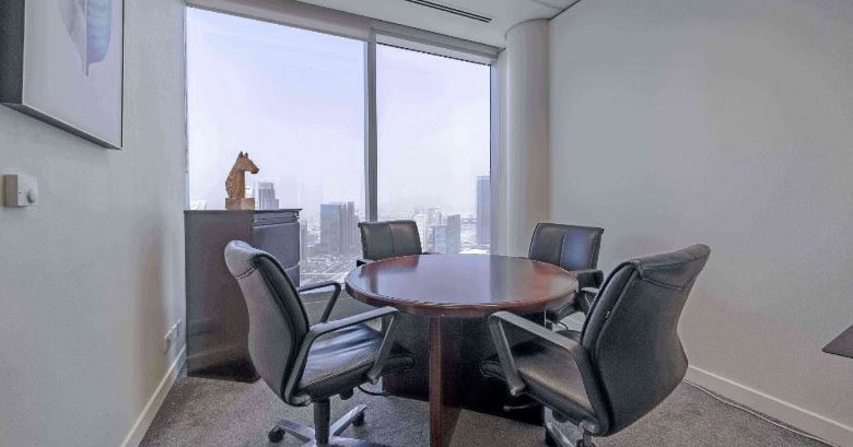 Modern Dubai office meeting room with large windows and executive chairs for collaboration.