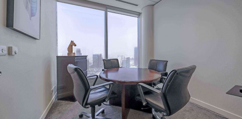 Modern Dubai office meeting room with large windows and executive chairs for collaboration.