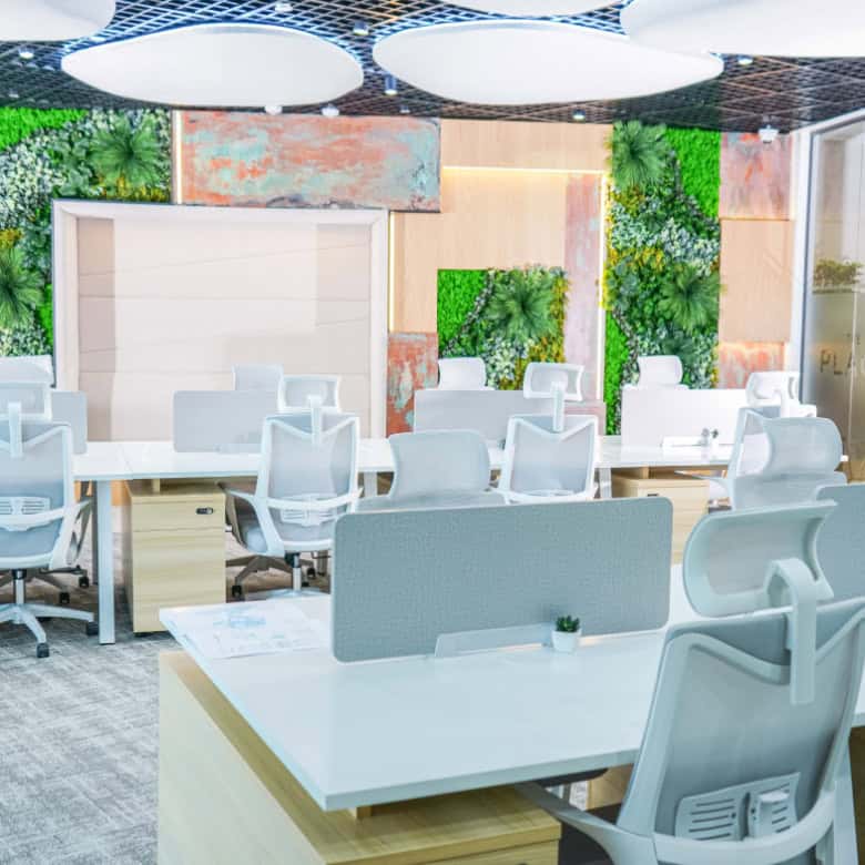 Bright open-plan UAE office with stylish furniture and green wall accents.