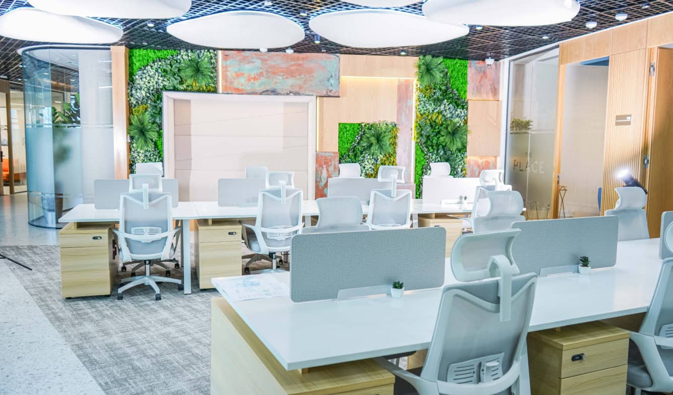 Bright open-plan UAE office with stylish furniture and green wall accents.
