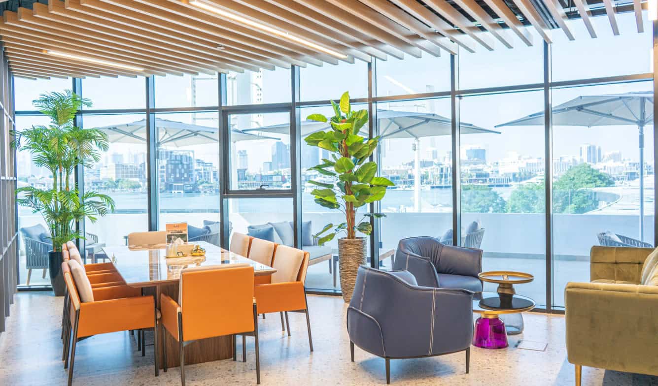 Bright, stylish coworking space with large windows and comfortable seating in Dubai UAE.