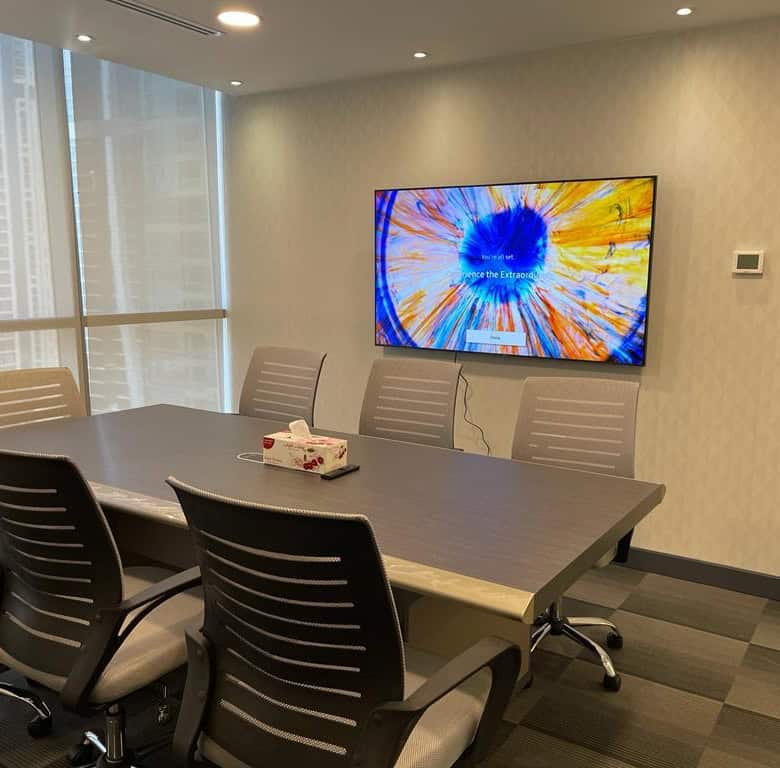 High-quality image of a contemporary conference room at Nextspace UAE with a digital screen and ergonomic chairs.