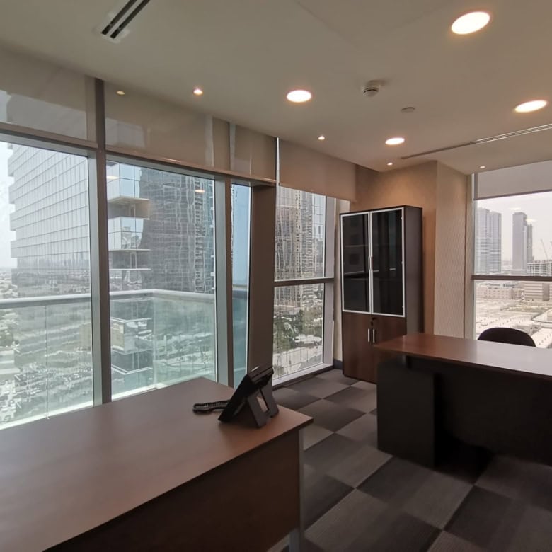 Bright office space with large windows overlooking Dubai skyline, perfect for professionals.