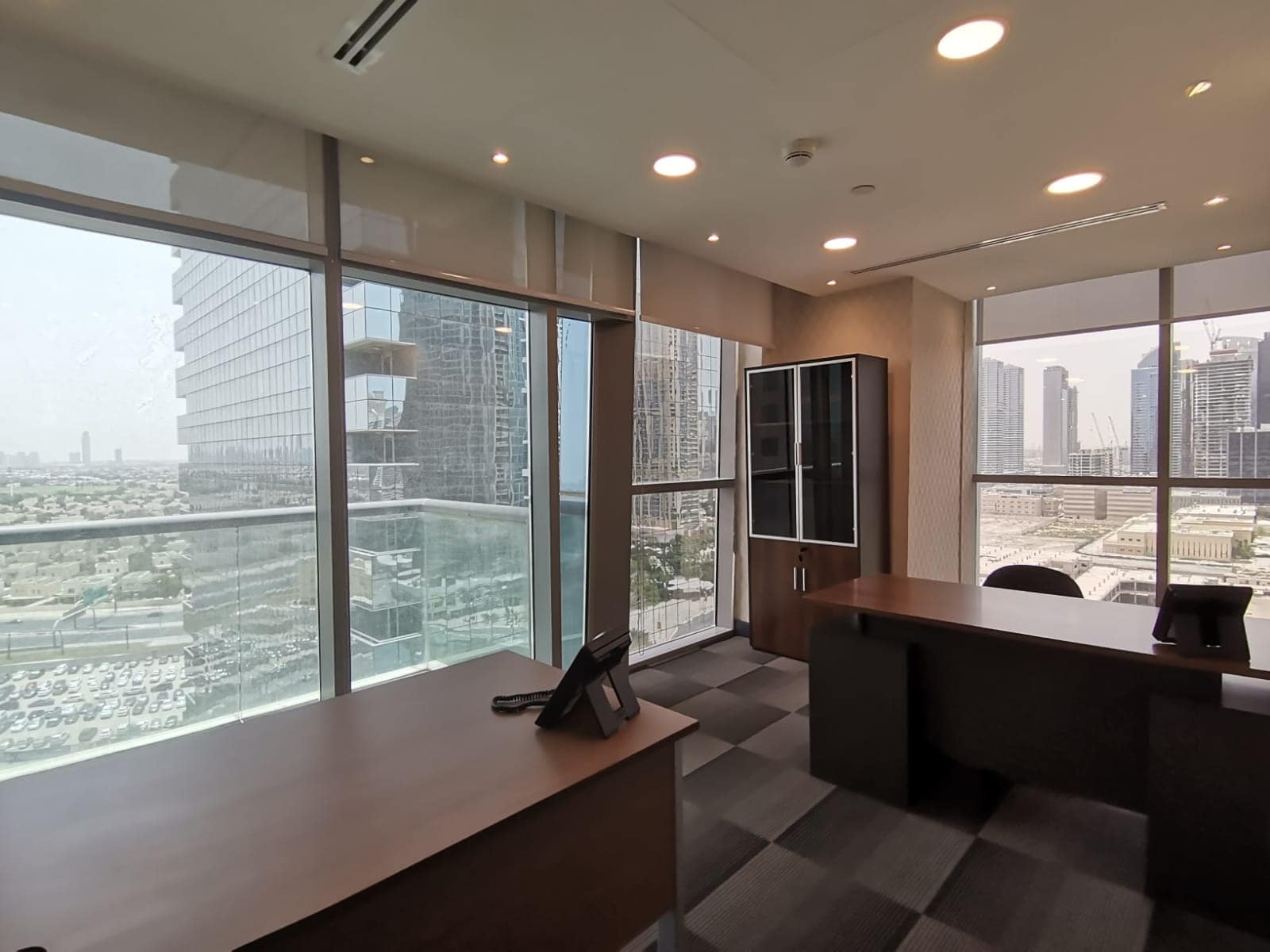 Bright office space with large windows overlooking Dubai skyline, perfect for professionals.