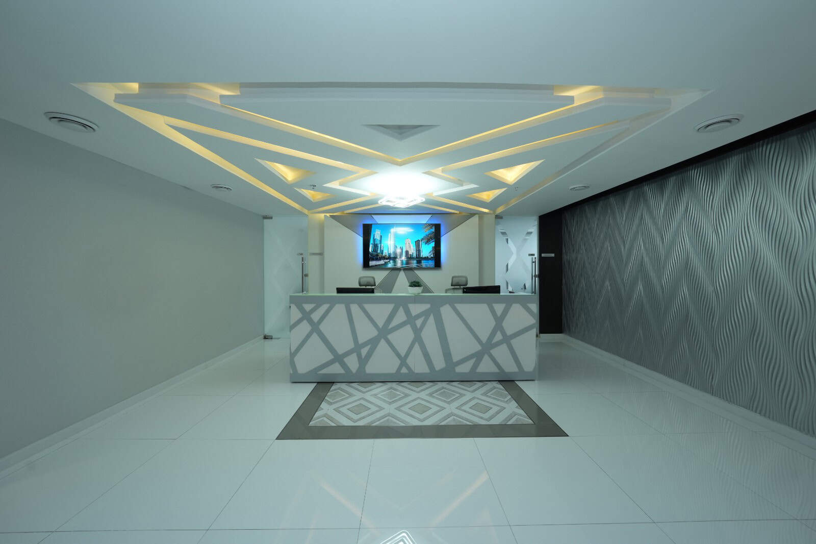 Stylish UAE coworking space reception with contemporary decor and digital display screen.
