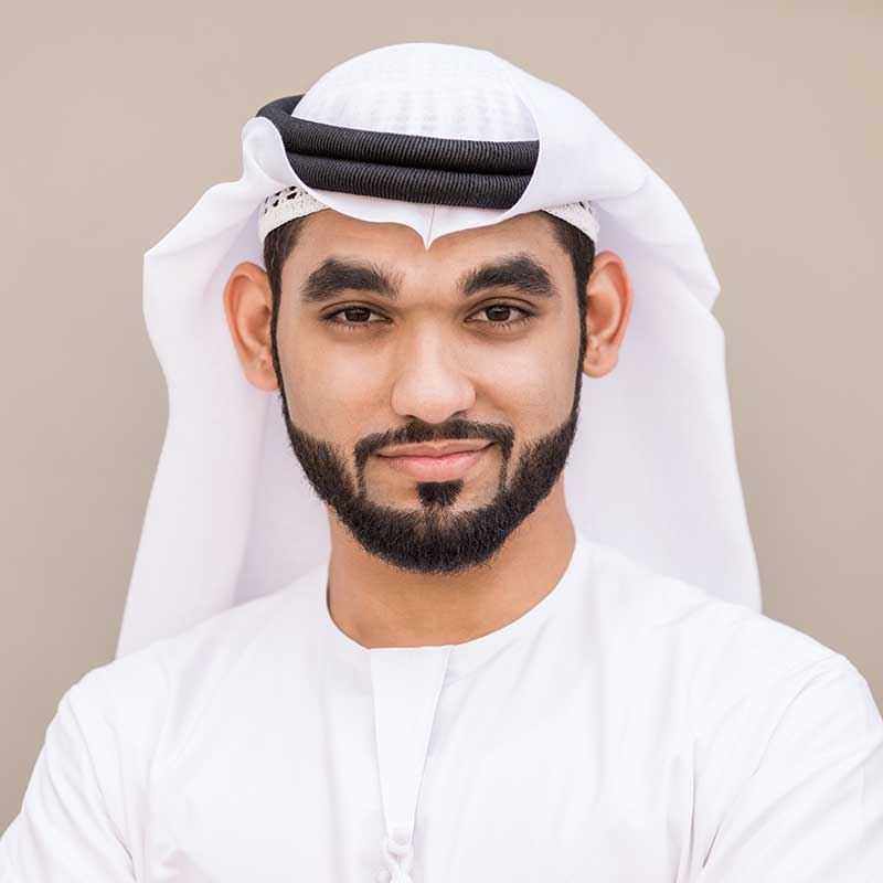 Men in traditional Emirati attire smiling confidently.