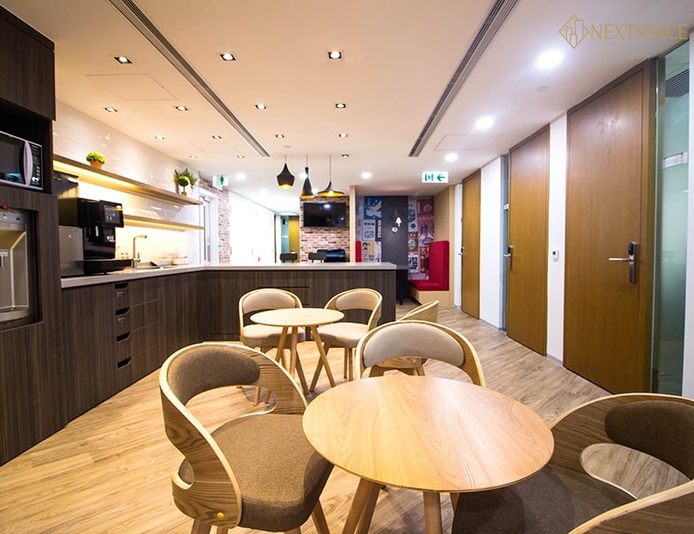 Office desks with chairs facing large window in Dubai business center.